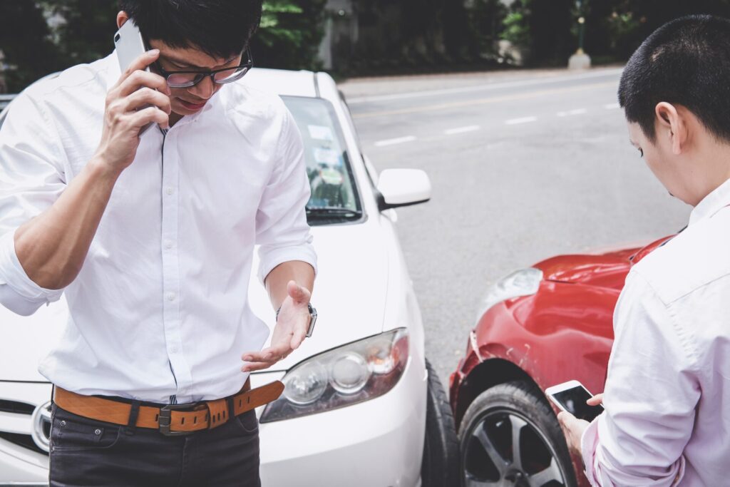 Two men in a car accident, calling car accident lawyer